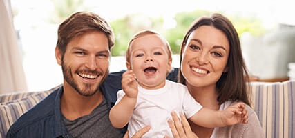 young couple with baby receives mother and daughter family dentistry